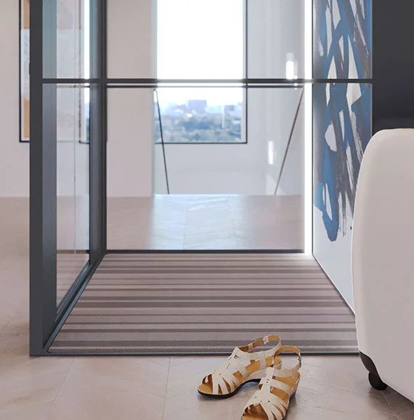 A SWIFT home lift with glass walls in a bright home, a pair of sandals waiting by the entrance